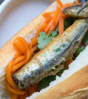 A banh mi sandwich with sardines, carrots, cilantro and cucumber