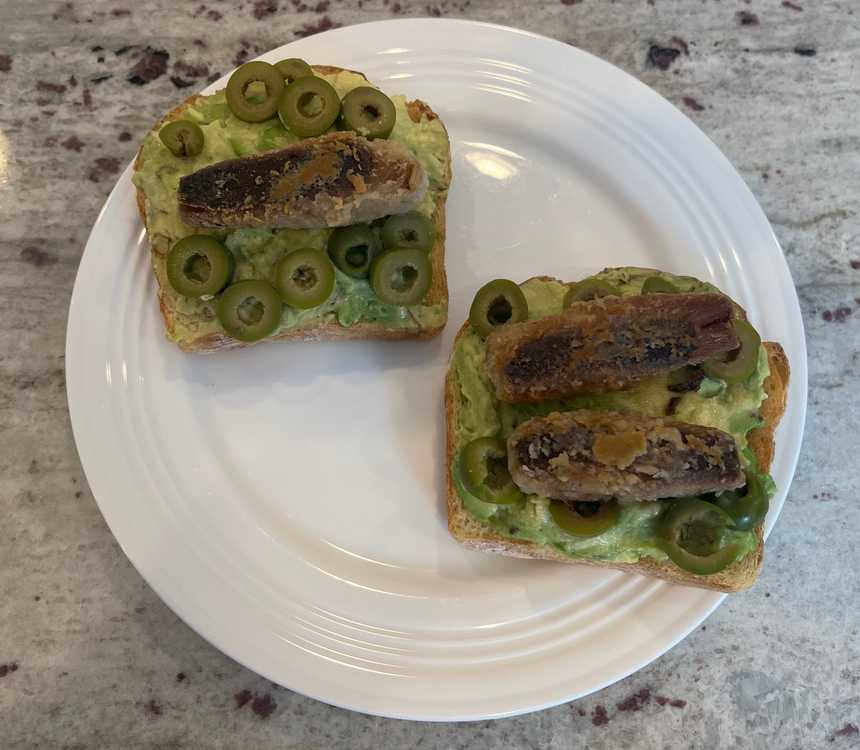 Two servings of avocado toast with sardines