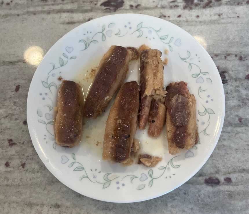 A tin of sardines opened and placed on a plate